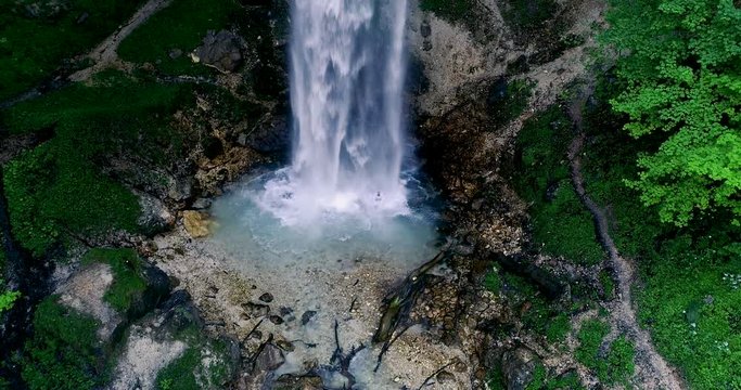 European man with beard is doing waterfall-meditation while standing under big waterfall in austria, wildensteiner waterfall