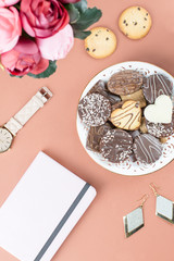 Flat lay home office desk. Feminine workspace with diary, flowers, sweets, fashion accessories. Fashion blogger concept.