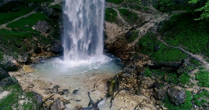 European man with beard is doing waterfall-meditation while standing under big waterfall in austria, wildensteiner waterfall
