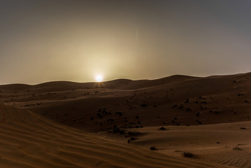 Fototapeta na wymiar The dunes of the Wahiba Sands desert in Oman at sunset during a typical summer sand storm - 25