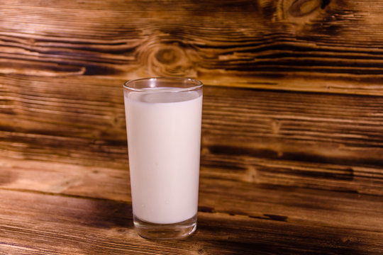 Full glass of milk on a wooden table