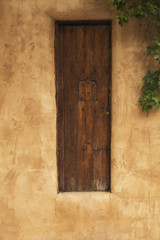 Fototapeta na wymiar Security Window in a Wooden Door in an Adobe Fence, Santa Fe, New Mexico