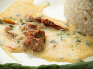 Chicken breast stuffed with asparagus in creamy sun-dried tomato sauce served with rice