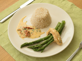 Chicken breast stuffed with asparagus in creamy sun-dried tomato sauce served with rice