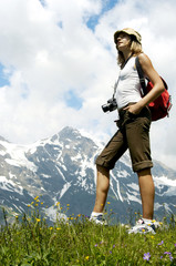 Naklejka na ściany i meble Woman Tourist in Mountains, Girl looking at Mountain Landscape, Active Summer Hiking Tourism In Nature