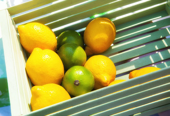 Wooden box with lemons and lime for cooking mojito