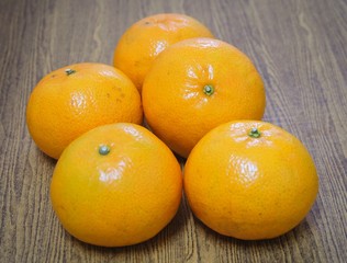 Five Ripe Oranges on A Wooden Table