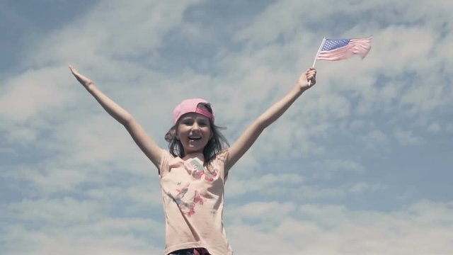 Girl waving US flag on the sky background slow motion HD