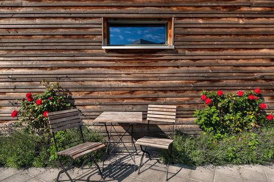 Zuhause Terrasse mit Holztisch Stuhl und blühenden Rosen