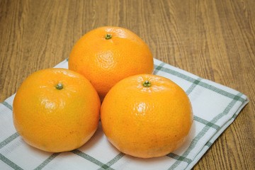 Three Ripe Oranges on A Wooden Table