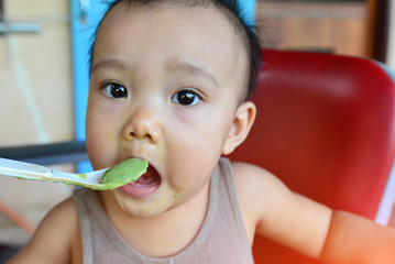 Face and gesture expression of Asian babies during eating time.