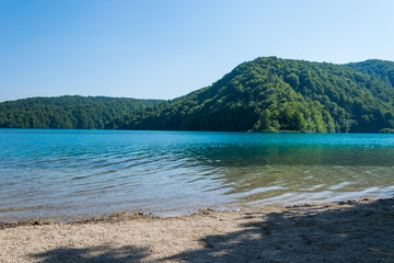 Plage sur un lac au pied d'une montagne