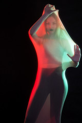 Girl posing in sportswear on a black background in a transparent bag