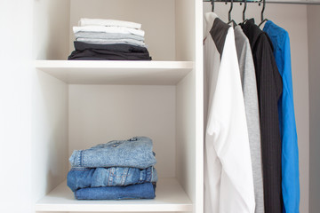 Neatly folded clothes in a light closet