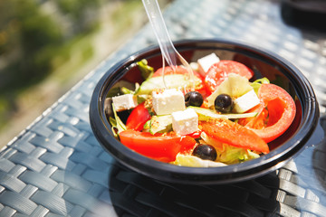 Greek salad on a plate on a table in a cafe