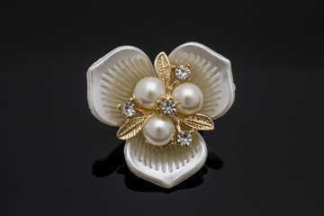 Brooch flower with pearls isolated on black
