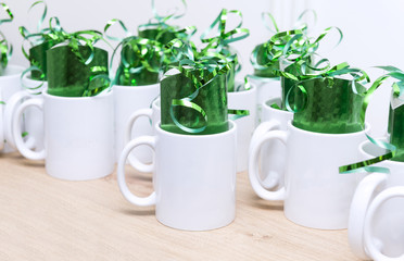 white mugs with green gifts inside