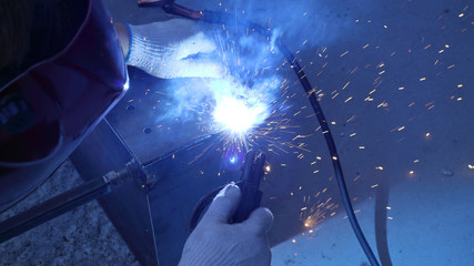 welder in the workplace, a lot of sparks and fire