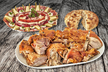 Garnished appetizer savory dish with plateful of fresh roasted pork meat slices and leavened flatbread torn loaf set on old weathered cracked pinewood garden table