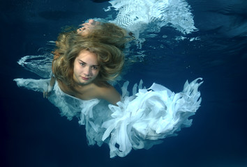 Young beautiful woman in the image of an angel underwater