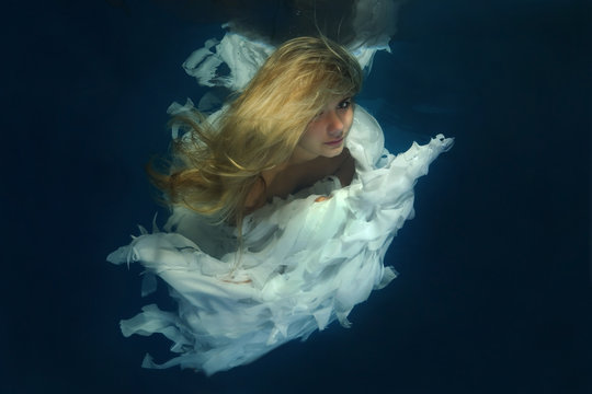 Young beautiful woman in the image of an angel underwater