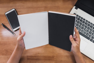 College students read books in the library. With computer and notebook