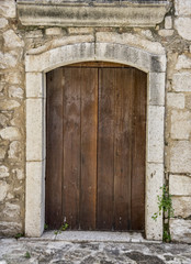 Fototapeta na wymiar Medieval wooden door, adorned with stone