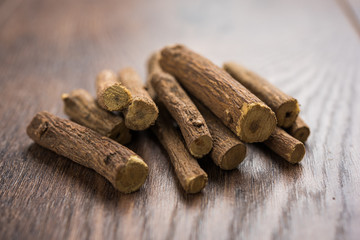 Ayurvedic Mulethi or Liquorice root stick or jeshthamadh powder served in a bowl over moody...