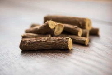 Ayurvedic Mulethi or Liquorice root stick or jeshthamadh powder served in a bowl over moody background