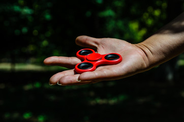 Red fidget spinner in female hand