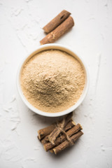 Ayurvedic Mulethi or Liquorice root stick or jeshthamadh powder served in a bowl over moody background