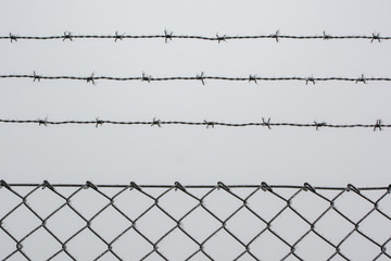 A fence against the white winter sky
