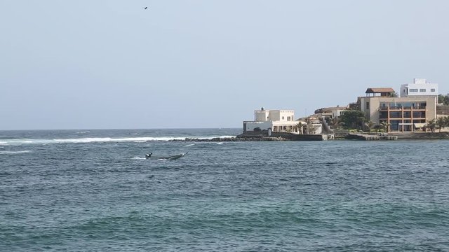 Sailing past Ngor beach in a little motor boat. This is a rural sea side town.