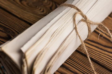 Roll of related old newspapers on old brown wooden table