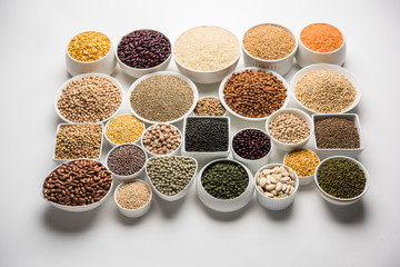 Uncooked pulses,grains and seeds in White bowls over white background. selective focus