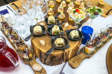 Beautiful catering banquet table with different food snacks and appetizers decorated for celebration party.