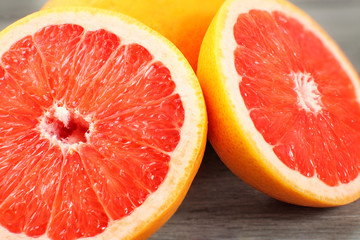 Closeup of pink grapefruit cut in half, on gray wood desk. © Lubo Ivanko