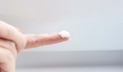 Girl's hand with cream on the finger