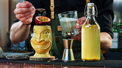 The bartender adorns the Tiki cocktail