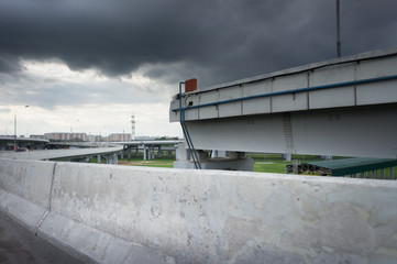 Urban Elevated Roads with concrete blocks on both sides. Black clouds on the sky. Storm is coming