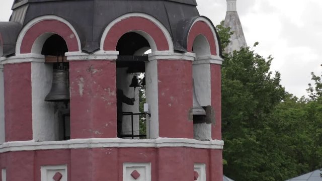 Russian Bell ringer on the bell tower rings bells.