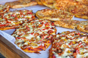 Ready pizza with meat and sausage background with vegetables. Summer holidays and food in nature. Stock Photo