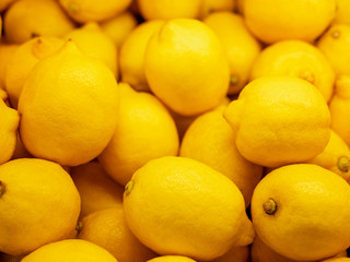 Closeup Colorful Display Of Lemons In Market. Background