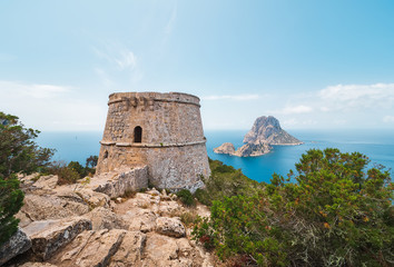 Fototapeta na wymiar hermoso paisaje del ocoeano y la Torre des savinar e islotes de Es VEdrá y Es Vedranell, desde un acantilado en el parque natural de cala D´hort en Ibiza, España. 
