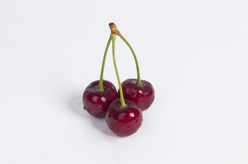 Three cherries on the white table