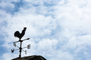 Weather Vane Silhouette against cloudy sky