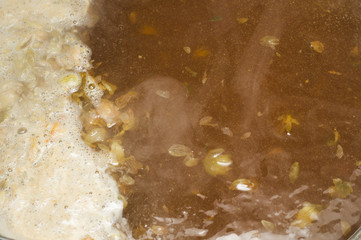 The initial stage of fermentation of craft beer with petals of hop on the surface. Craft beer...