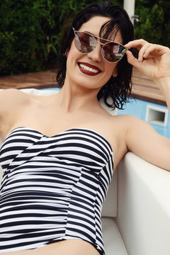 beautiful smiling woman portrait in fashion swimsuit and sunglasses