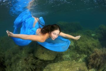 Young woman in a blue dress swims under the water - Black Sea, Crimea