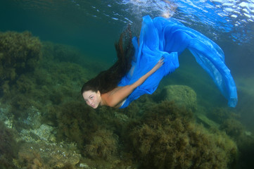 Young woman in a blue dress swims under the water - Black Sea, Crimea